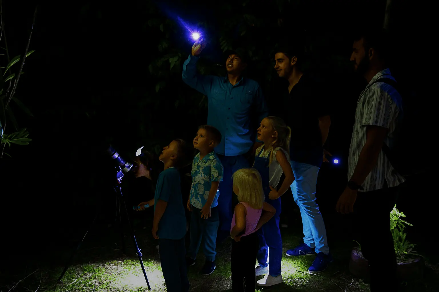 Guided night walk near Arenal Volcano with families observing nocturnal wildlife in the Costa Rican rainforest.
